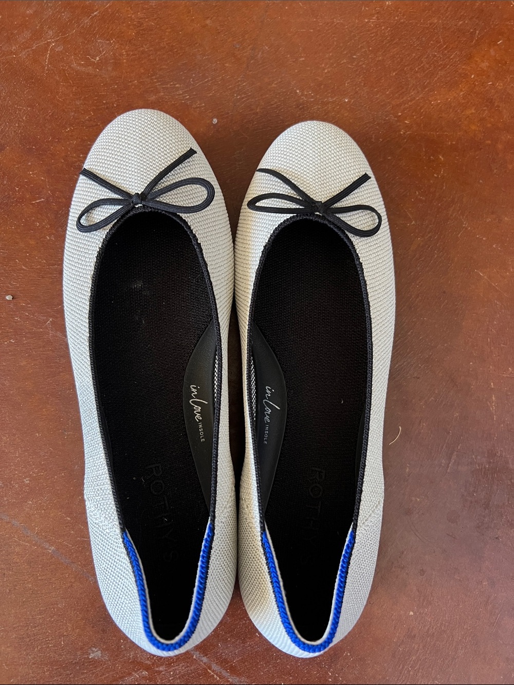 Rothy's Ivory Ballet Flats with Black Trim and Blue Heel Accent